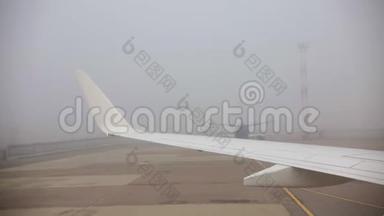 旅行概念。 从飞机窗口观看。 一架飞机在雾天降落.